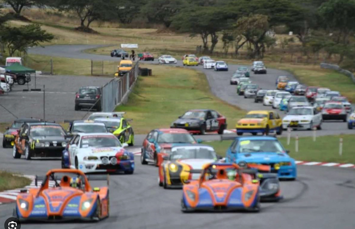 Gran grupo de autos de carrera compitiendo en el Autódromo de Yahuarcocha con el auspicio de S-OIL SEVEN.