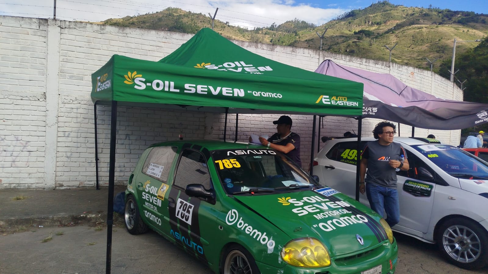 Vehículo de carreras verde bajo carpa de S-OIL SEVEN y Aramco en los pits del Gran Premio Ciudad de Paute 2026.